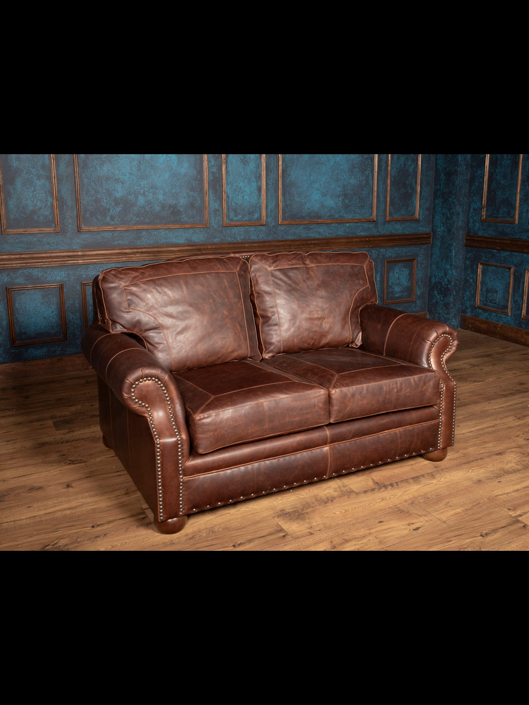 Angled front view of brown leather loveseat