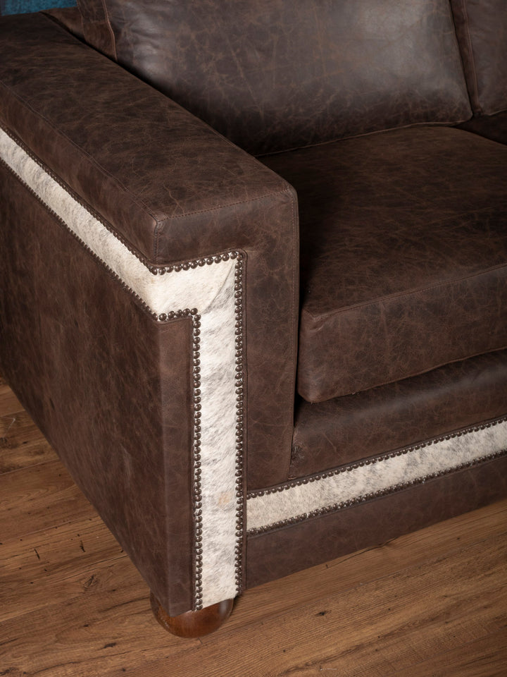 Side angle of Granite Architect Sofa featuring dark brown leather and rustic Western design elements
