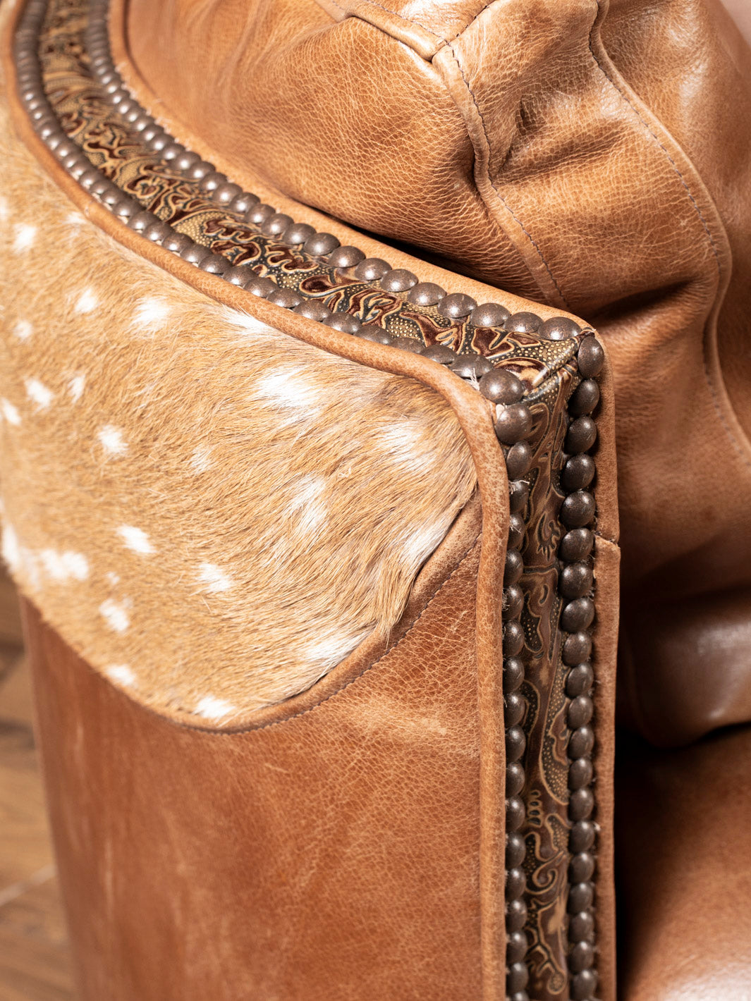 Close-up of Axis hide and embossed leather detailing on luxury Western swivel recliner chair