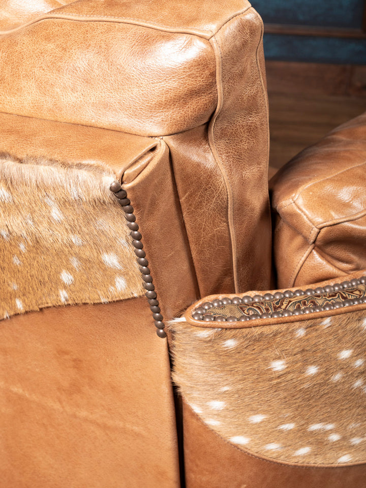 Close-up of a brown leather armchair with axis accents
