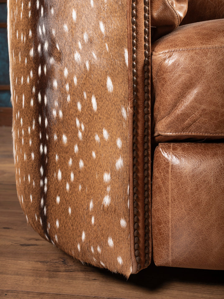 Lower side close-up of recliner with axis hide pattern Genuine axis hide panel with stitched trim on rustic leather recliner.