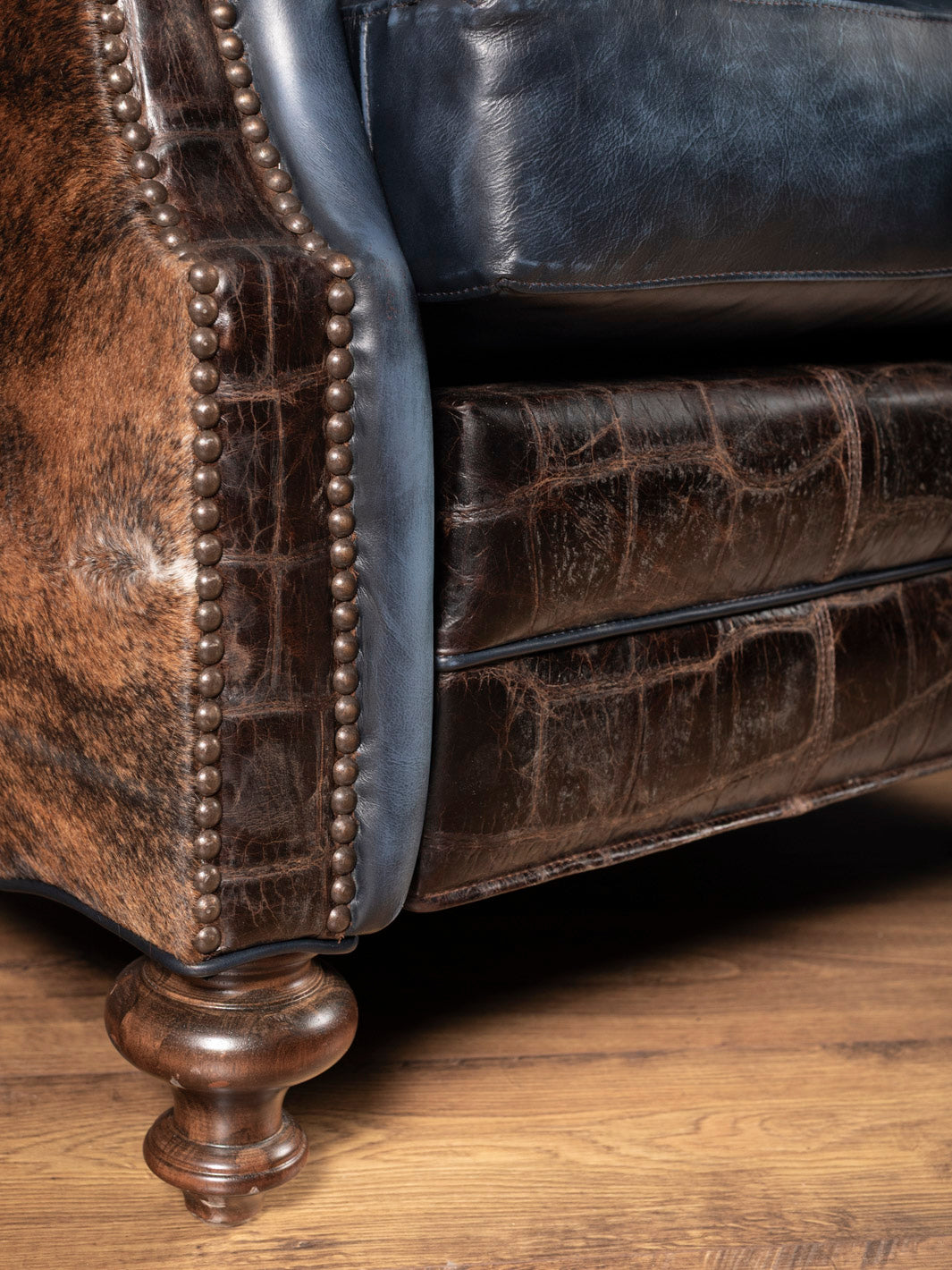 Embossed croc leather recliner footrest with turned wood legs and cowhide accents in a luxury handcrafted Western design