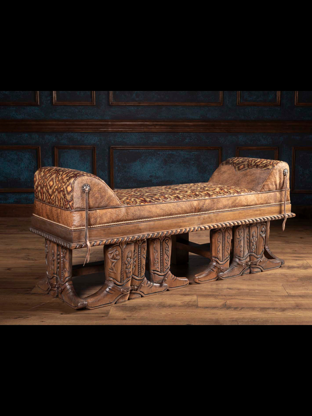 Side view of a Western bench with cowboy boot-shaped carved legs and leather upholstery.