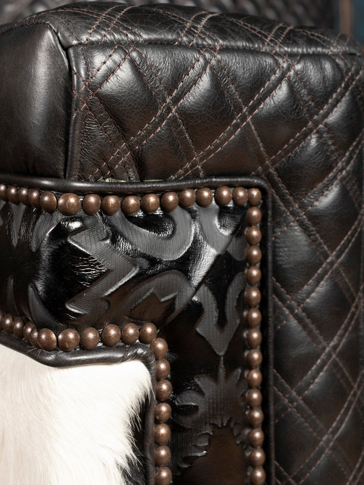 Close-up of a black leather chair with decorative metal accents