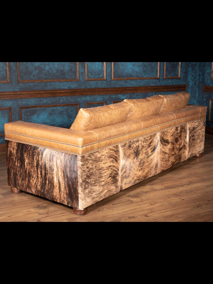 Back view of Western leather and cowhide sofa with hair on hide panels and warm brown leather trim