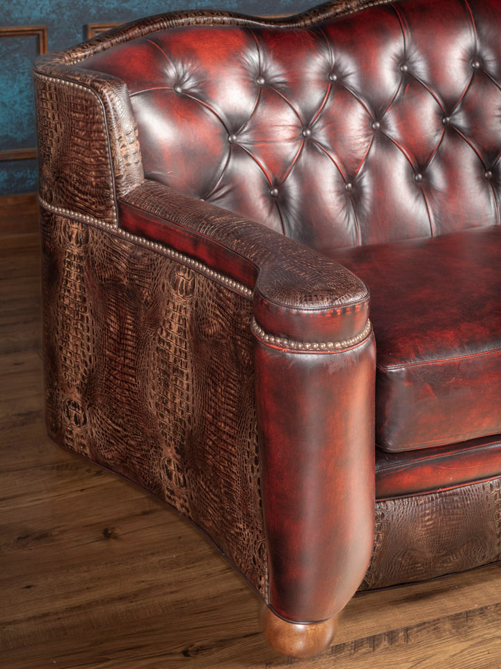 Detailed tufted red leather backrest and crocodile embossed arm of custom loveseat