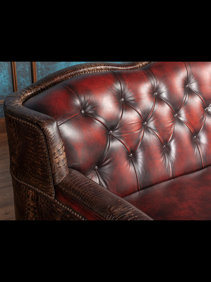 Close-up of a red leather sofa with tufted backrest.