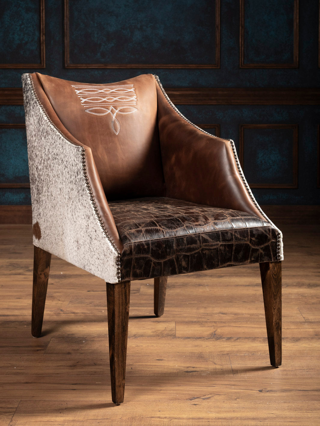 Front angle view of western leather arm chair with gator embossed seat and speckled cowhide accents on outside arms