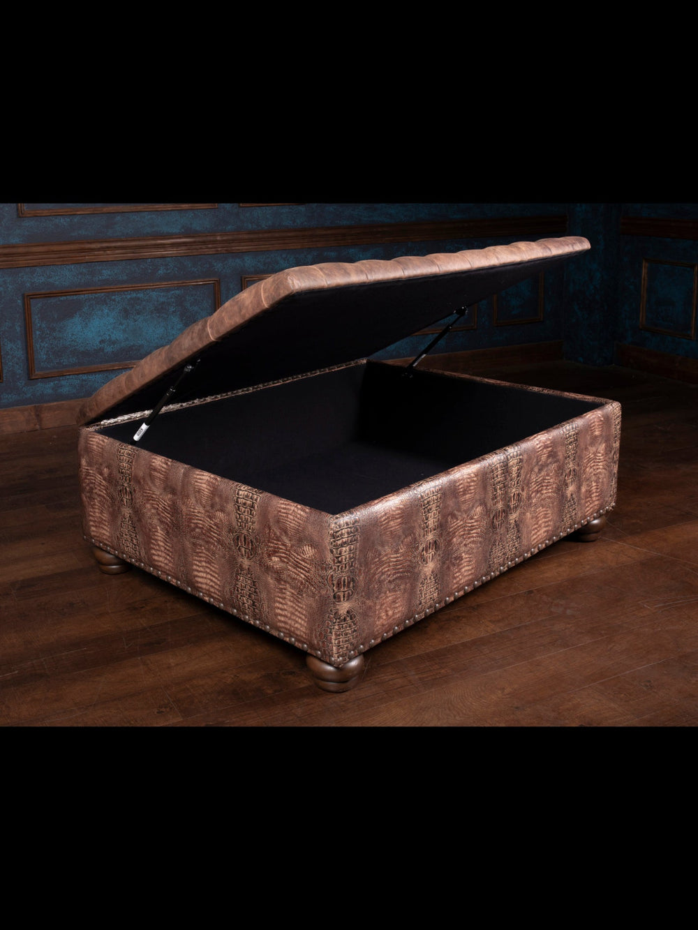 Brown leather ottoman with open lid on a wooden floor.