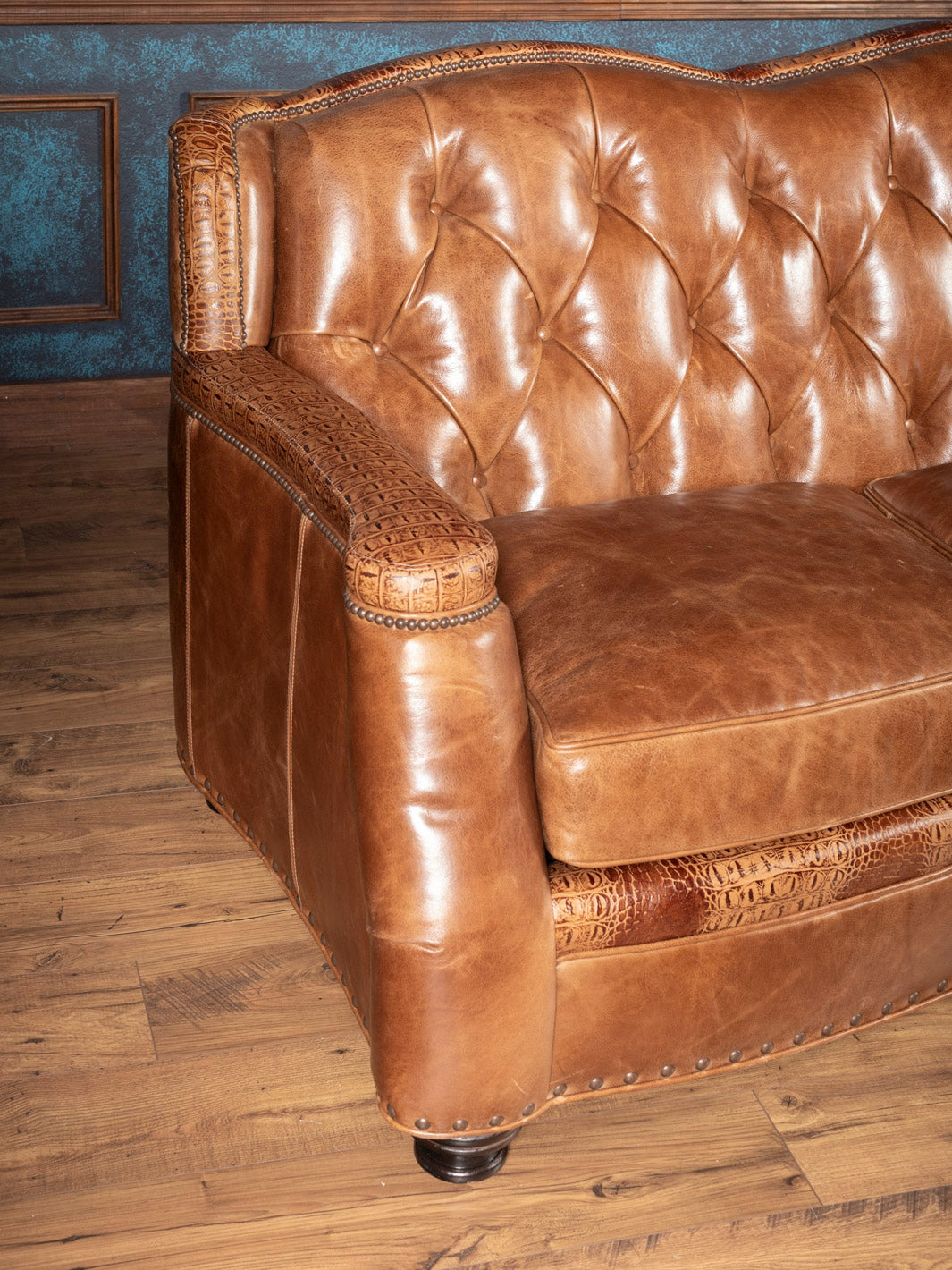 Side view of tufted brown leather sofa with croc accents