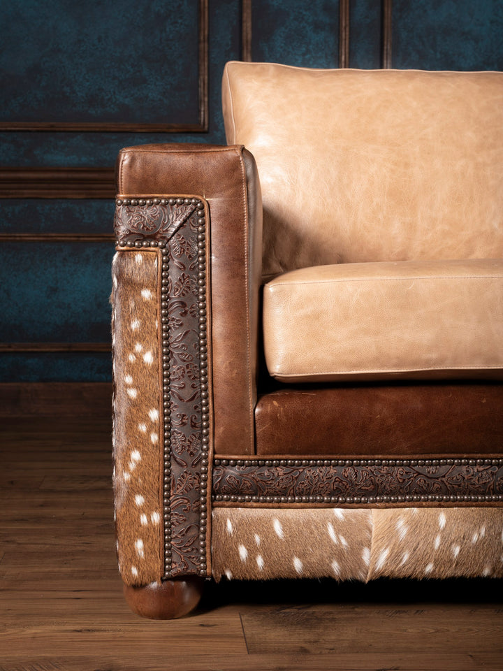 Close-up of axis deer hide and embossed leather trim on the Sandstone Axis Leather Sofa with Western-style nailhead accents