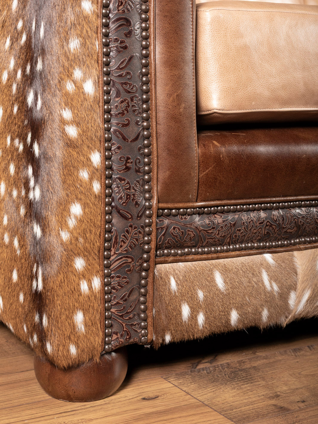 Brown leather sofa with deer hide pattern on a wooden floor