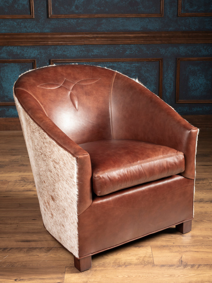 Brown leather armchair with textured backrest against a wooden paneled wall.