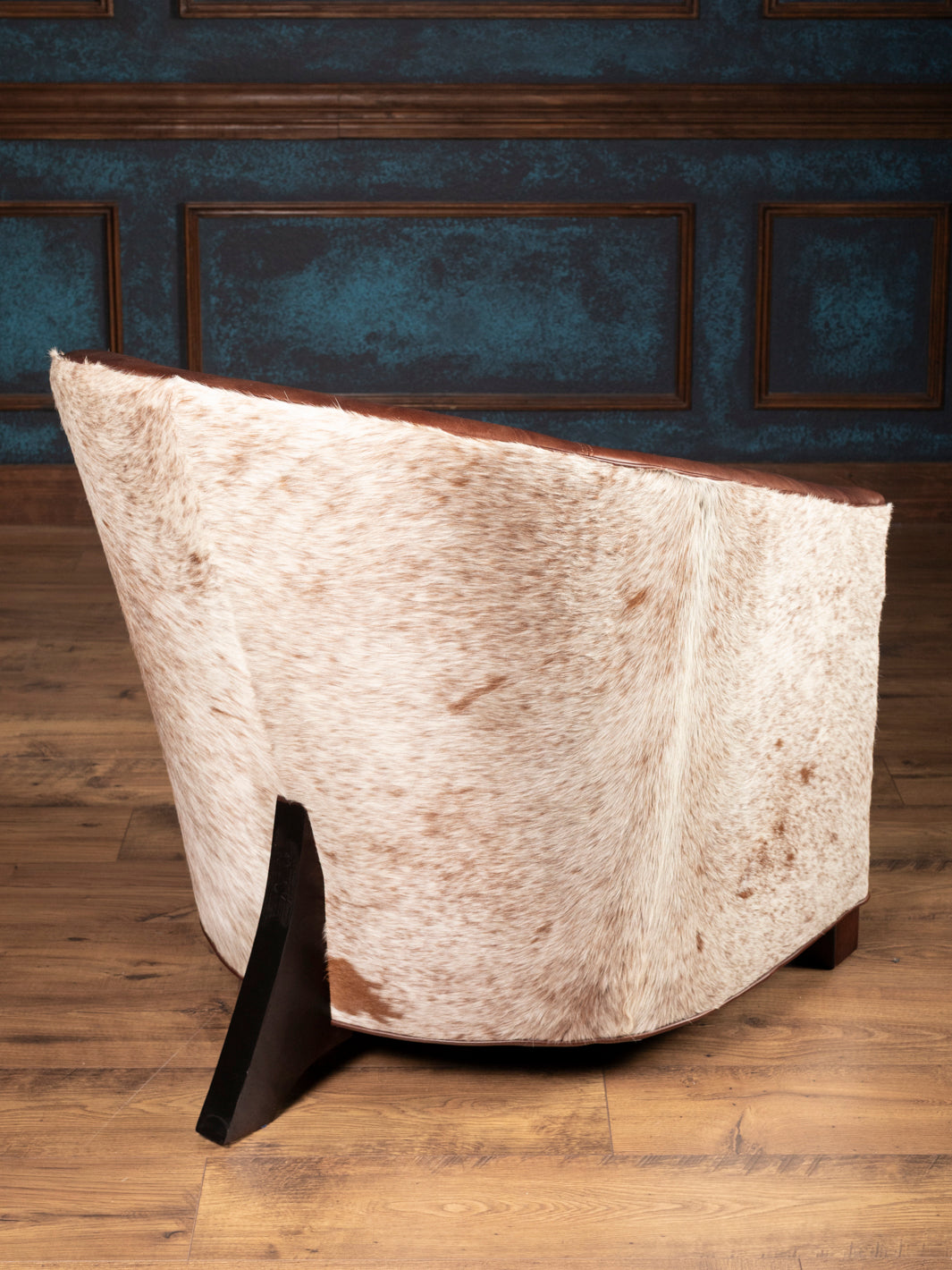 Back view of speckled cowhide barrel accent chair for ranch-style living room décor