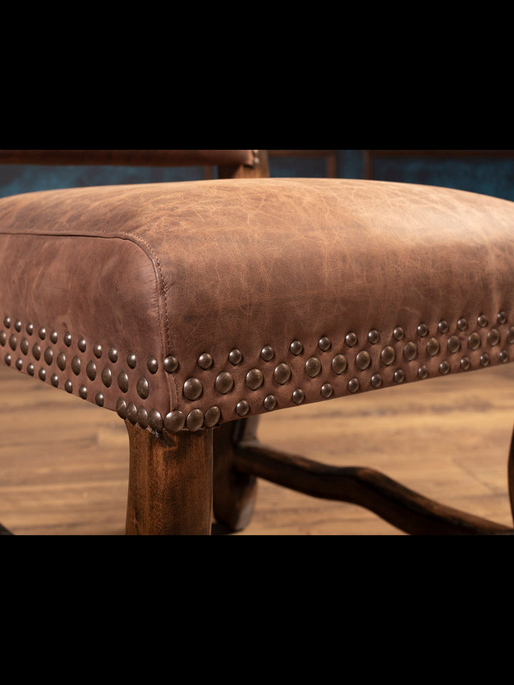 Close up shot of brown leather seat with nailhead accents