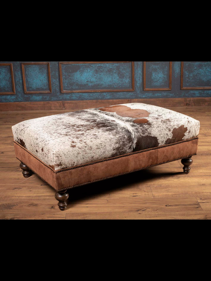 Square cowhide and leather rustic ottoman with genuine cowhide top, brown suede sides, and turned wood legs