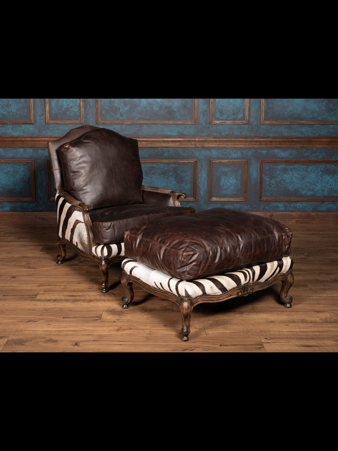 Matching zebra hide ottoman with leather trim and exotic safari-inspired styling