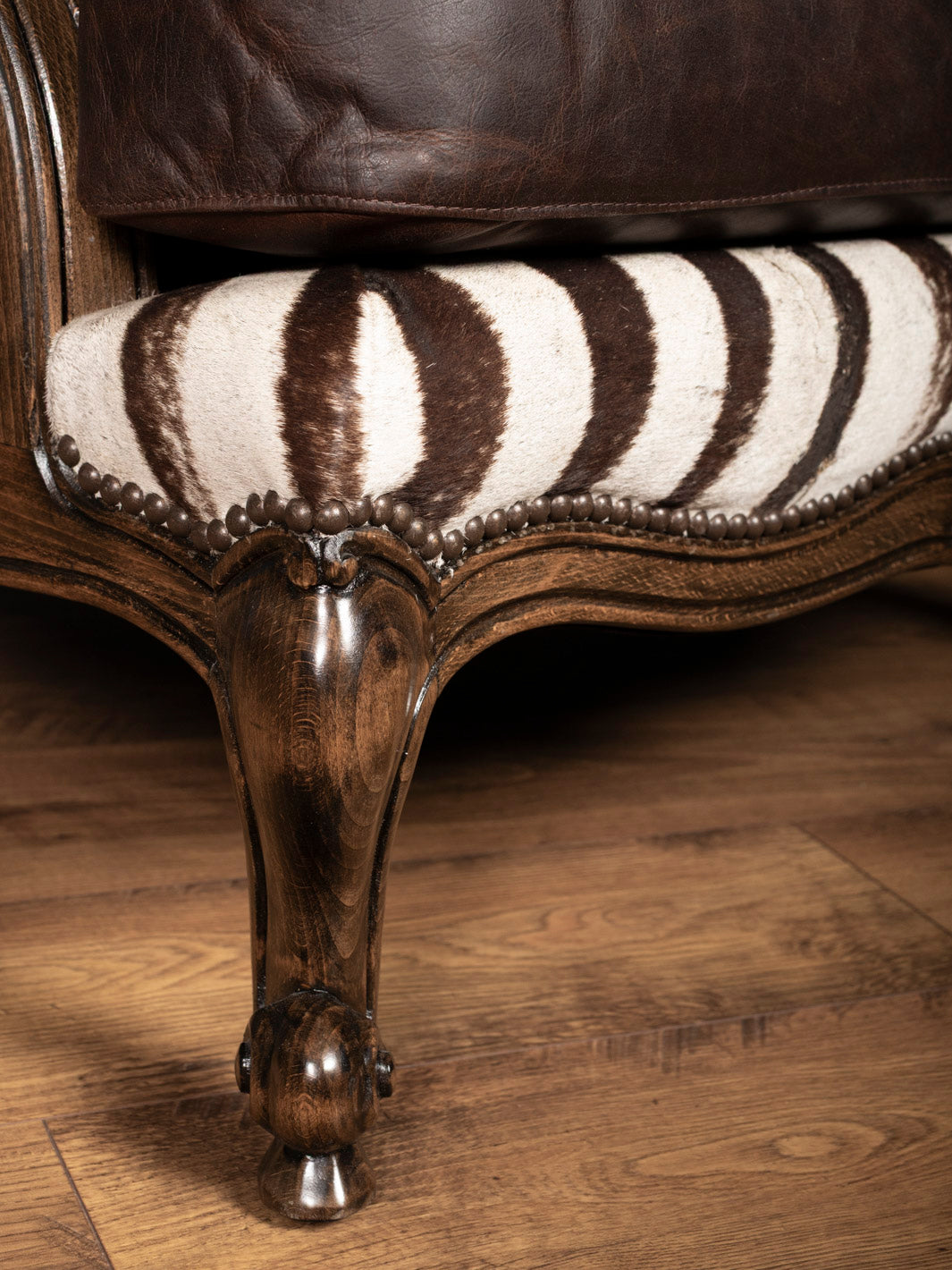 Luxury zebra hide chair with vintage wooden bun feet and artisan nailhead trim