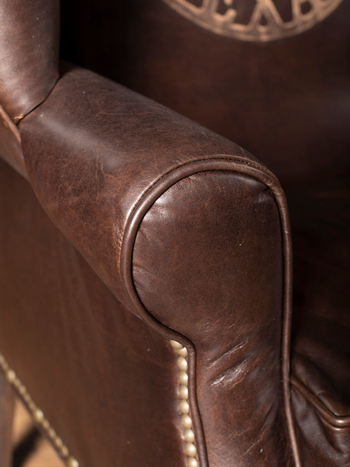Close-up of rolled arm and nailhead trim on Texas Legacy Leather Wingback Chair in full-grain brown leather