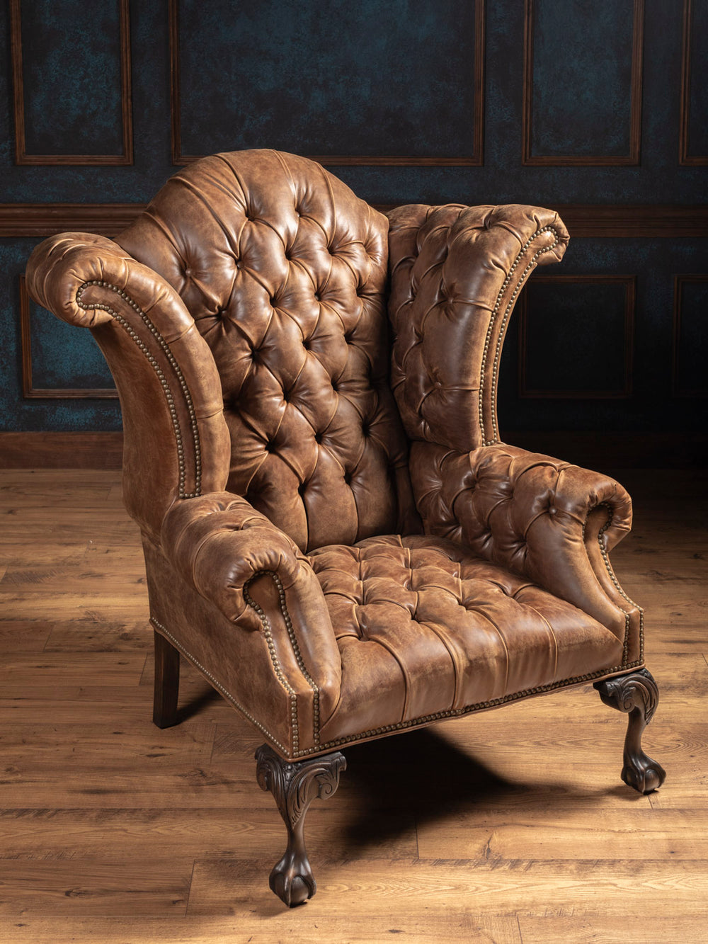 Side angle of handcrafted tobacco brown leather chair showcasing button tufting and nailhead trim