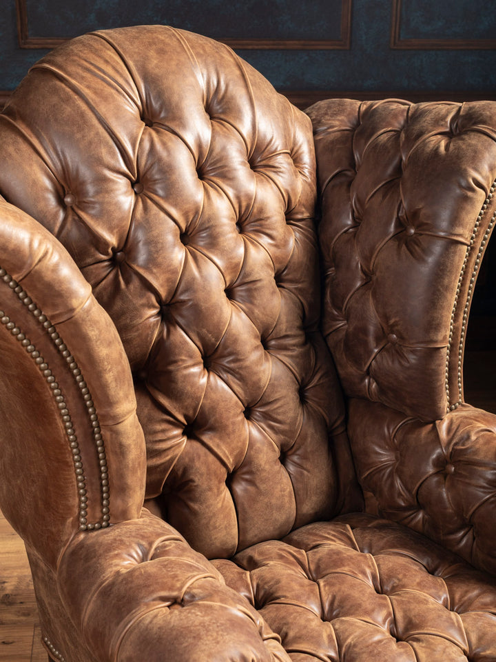 Top-down view of button tufting on seat cushion of luxury Western leather accent chair