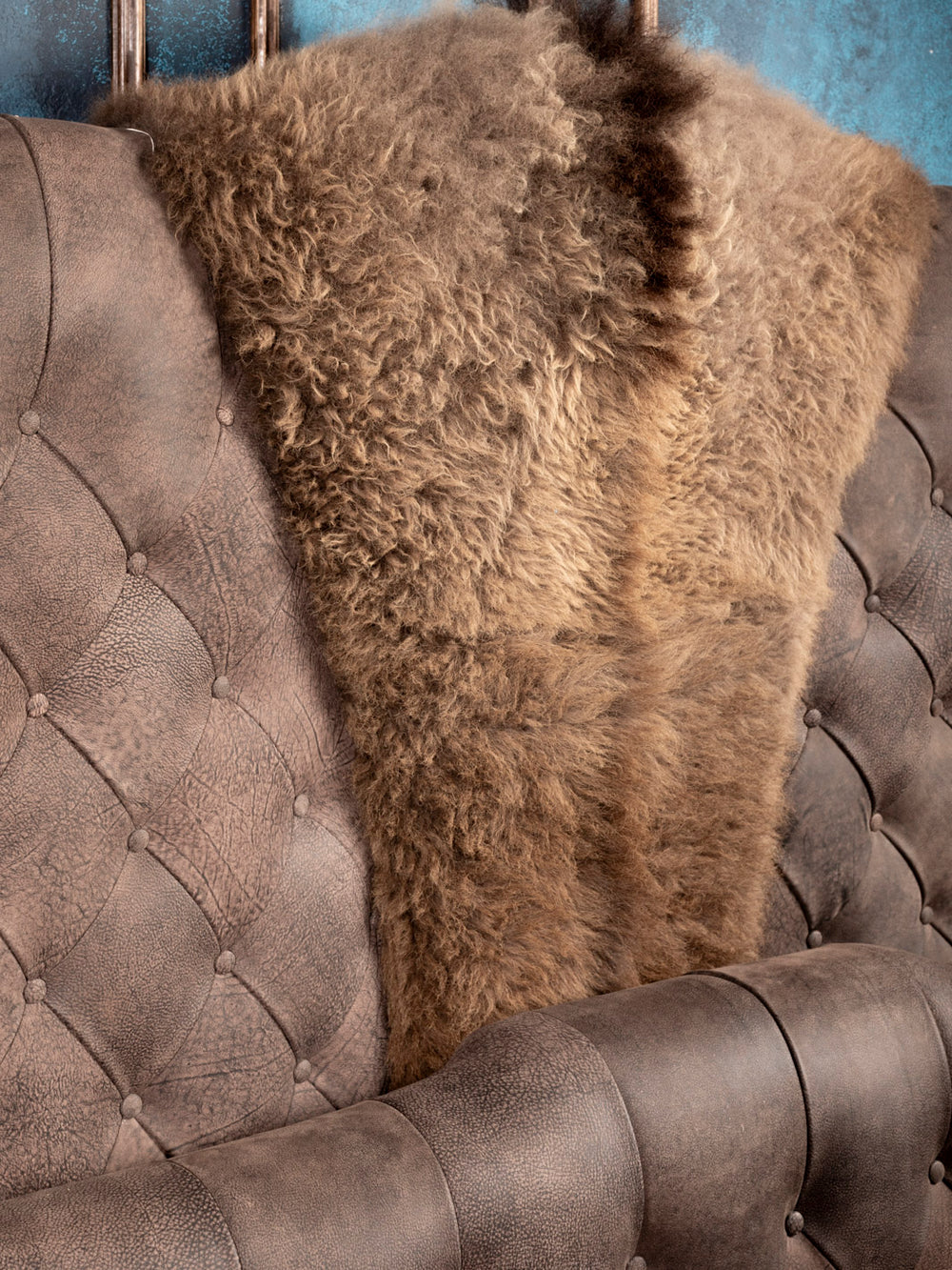 Close up shot of tufted headboard with centered brown buffalo hide inlay