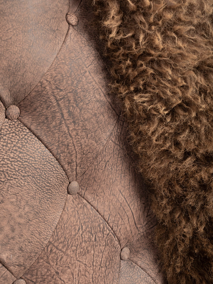 Close-up of a textured brown leather and tufted button details