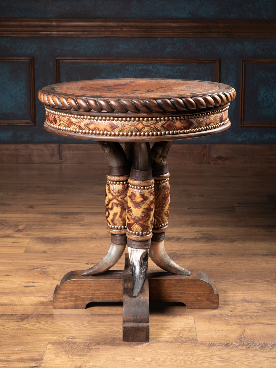 Rustic western end table with hand-carved copper inlay top and genuine steer horn pedestal base wrapped in tooled leather.