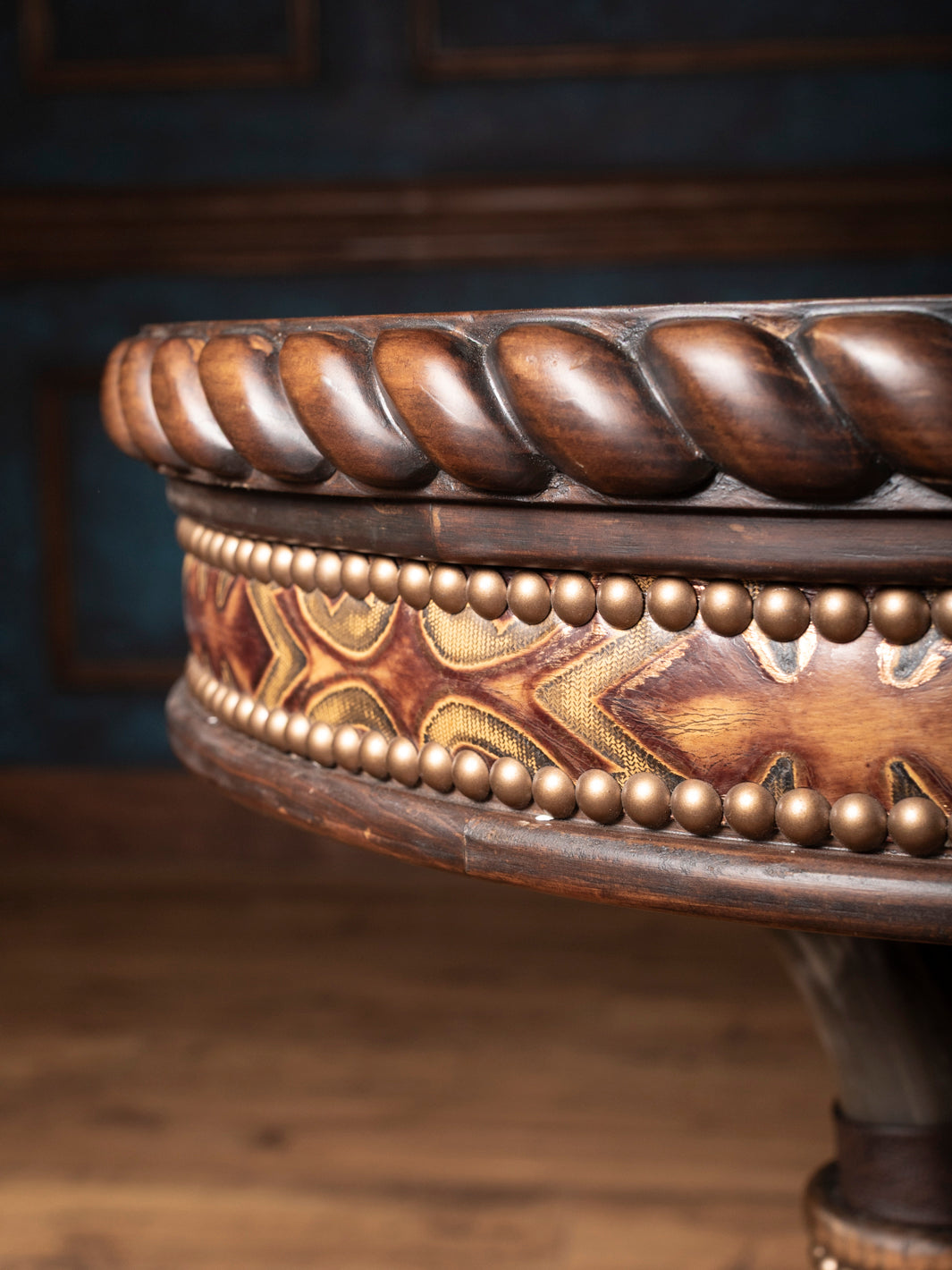 Detailed shot of carved rope-edge wood trim and decorative tooled leather accents on western pedestal end table.