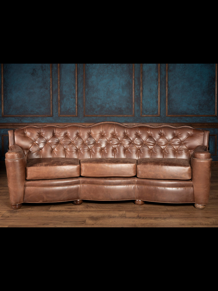 Front-facing full view: Western-style brown leather and cowhide Utah sofa with tufted back and sculpted arms