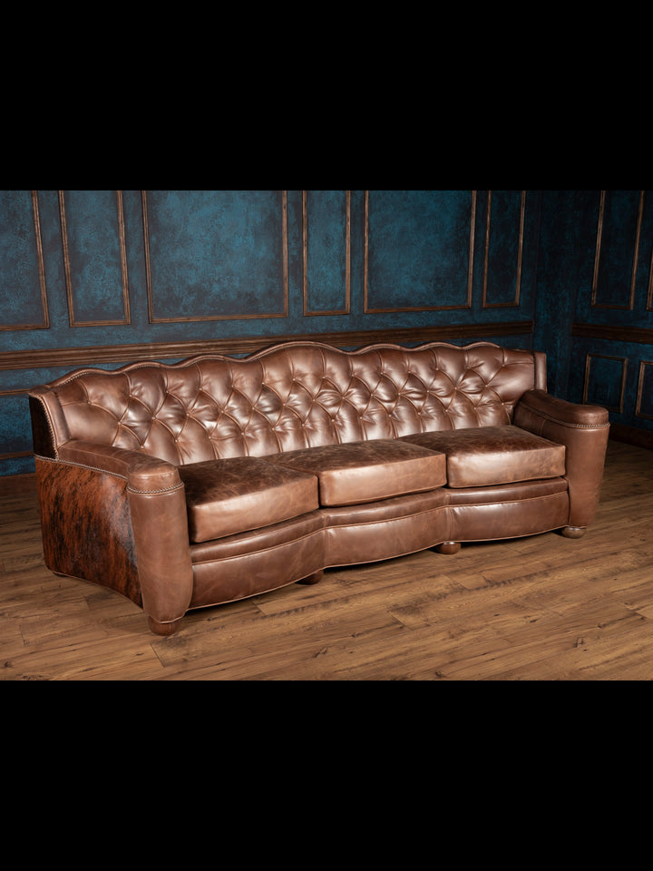 Angled full view: Three-seat brown leather Western sofa with rustic cowhide detailing