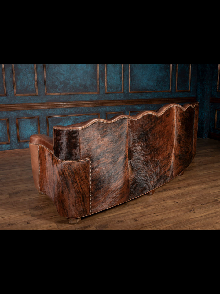 Back view: Full cowhide back panel on curved Western leather sofa
