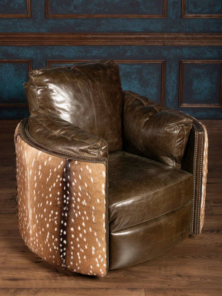green leather armchair with a deer hide pattern on a wooden floor and blue paneled wall.