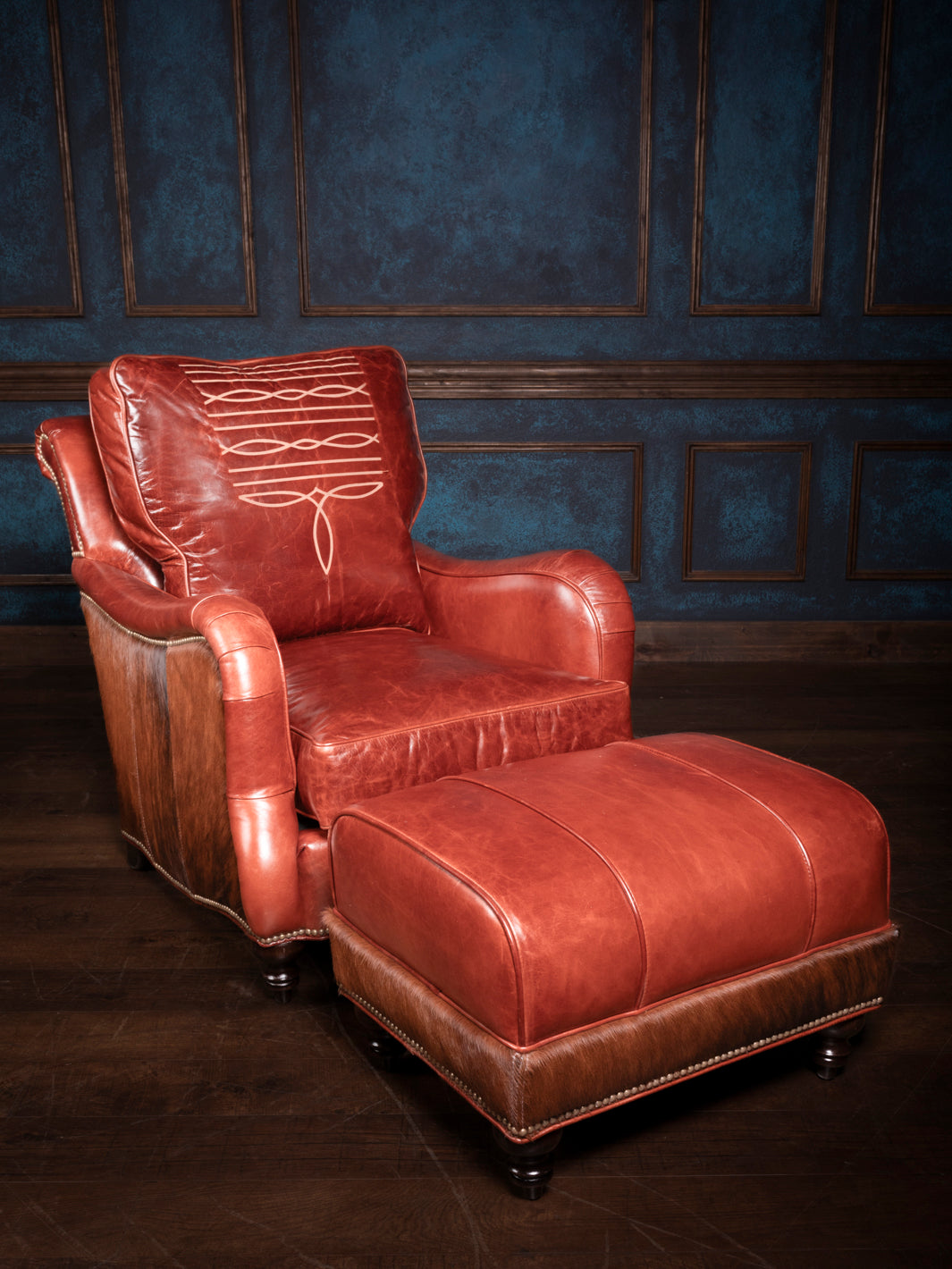 Amarillo Red Stitch Accent Chair and Ottoman in full-grain leather with cowhide accents in a rustic living space.