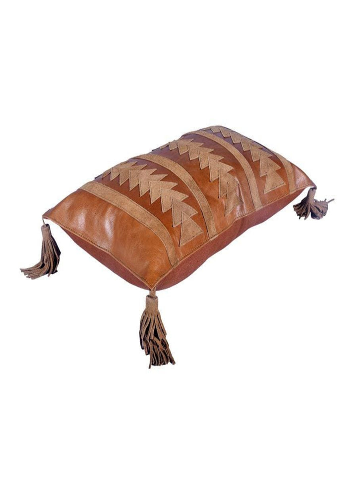A brown leather lumbar pillow with a suede top featuring a southwestern-inspired arrow pattern and leather tassels.
