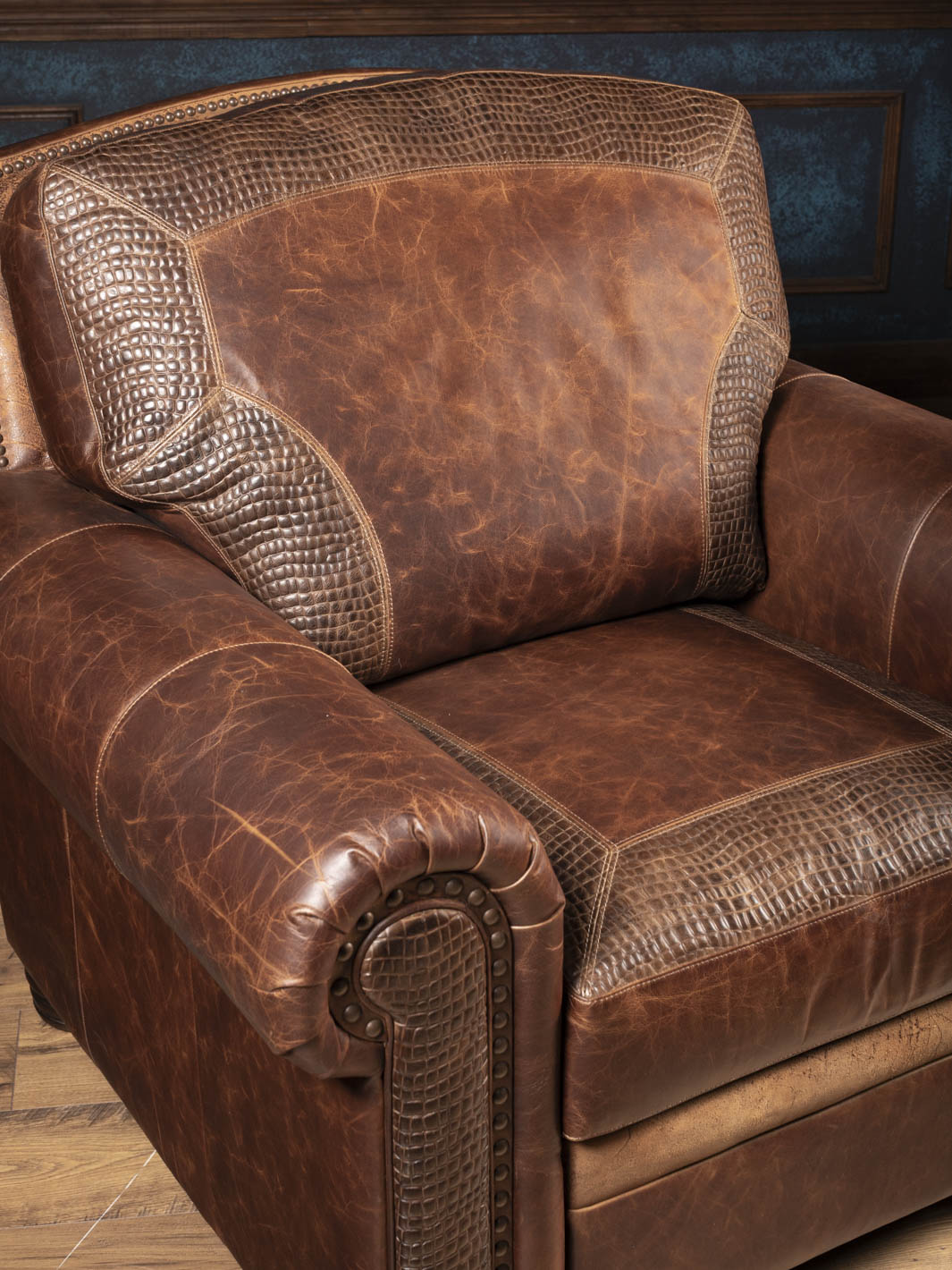Close-up of the alligator embossed leather panel on the back cushion and rolled arm