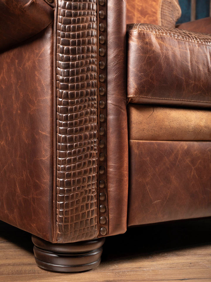 Close-up of the alligator embossed leather trim and turned wood leg on the Bison Leather Power Recliner