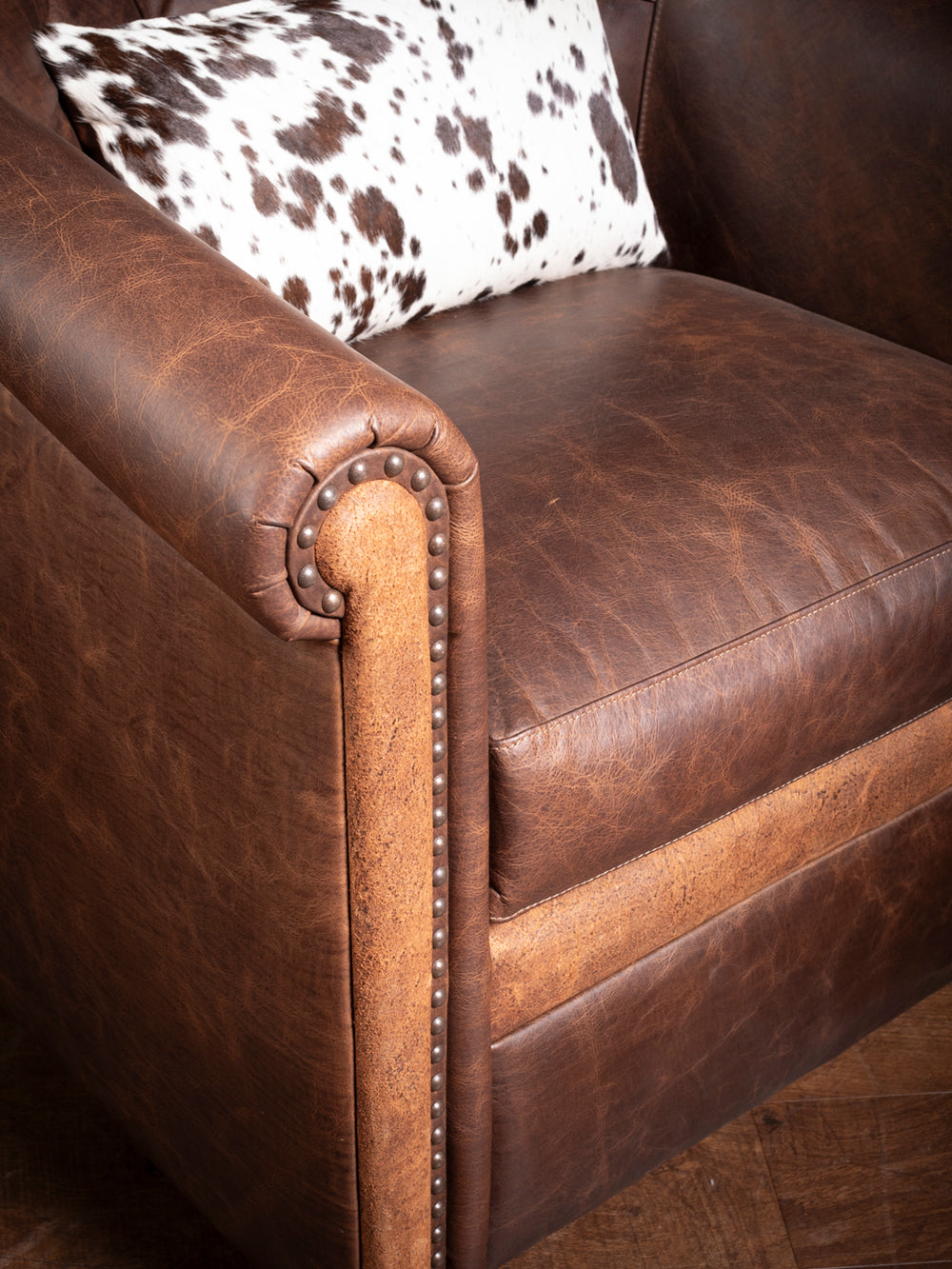 Close-up view of Bison Ridge leather swivel chair's plush seating and detailed stitching, ideal for upscale living spaces.