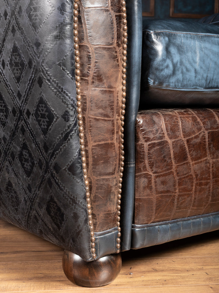 Blue Leather Cigar Chair in blue leather with crocodile embossed leather trim detailing in a close up view.