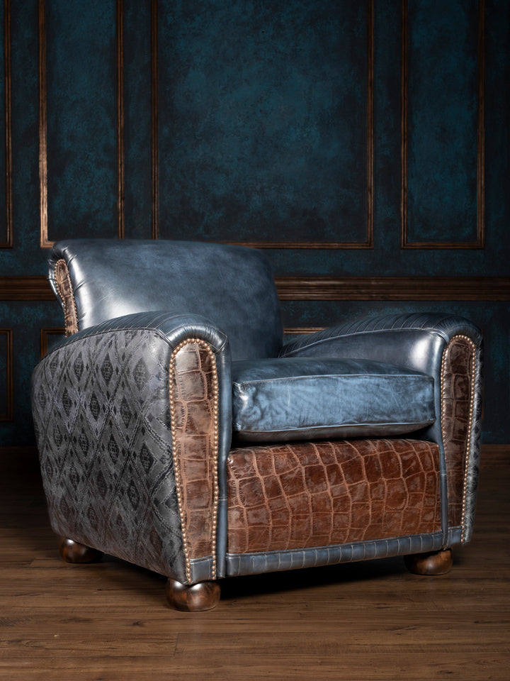 Blue Leather Cigar Chair in full grain blue leather with embossed diamond outside back panels and crocodile leather trim in a rustic living space. 