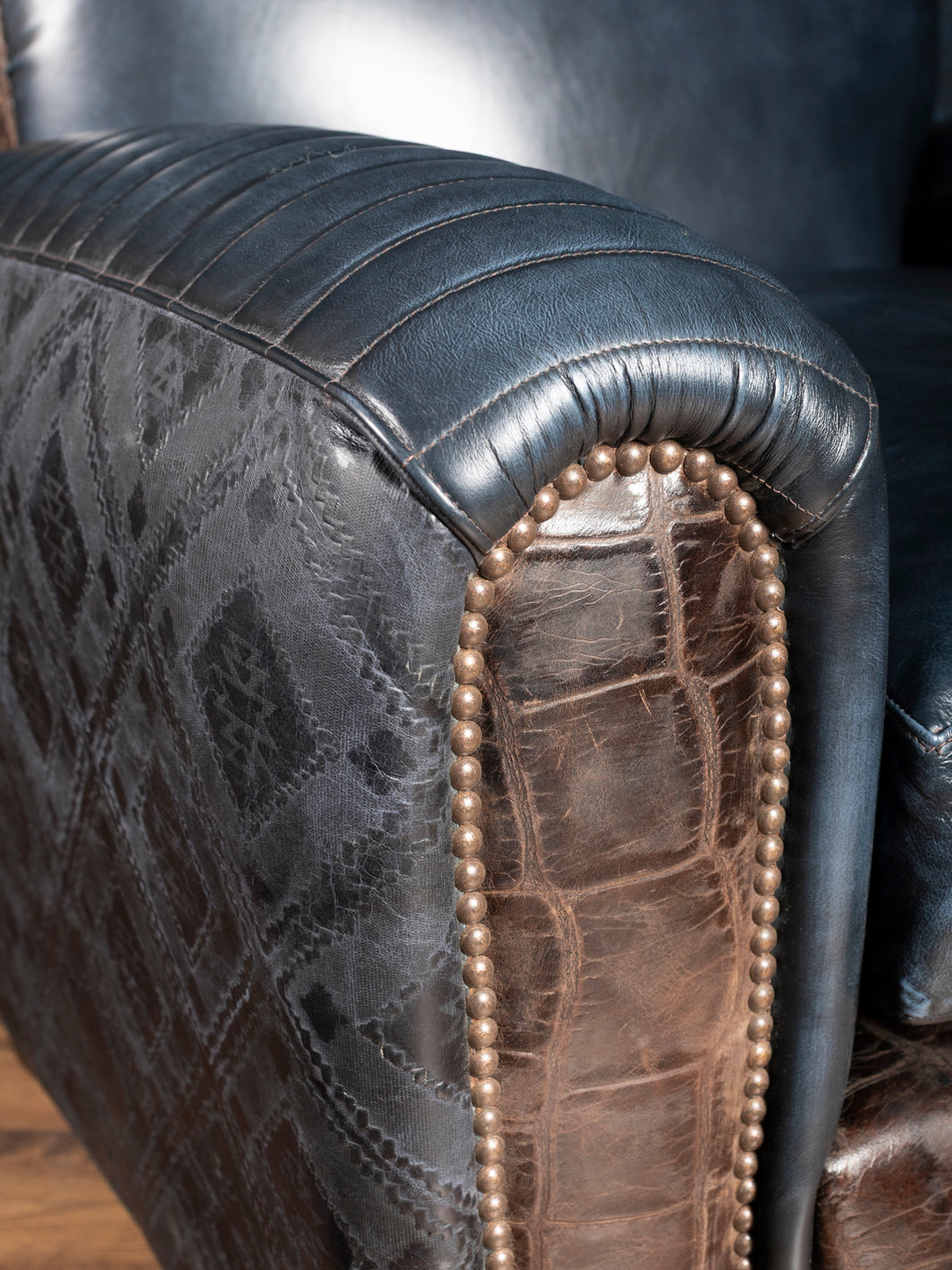 Blue Leather Cigar Chair with rolled stitched blue leather arm and crocodile leather trim accents in a close up view.