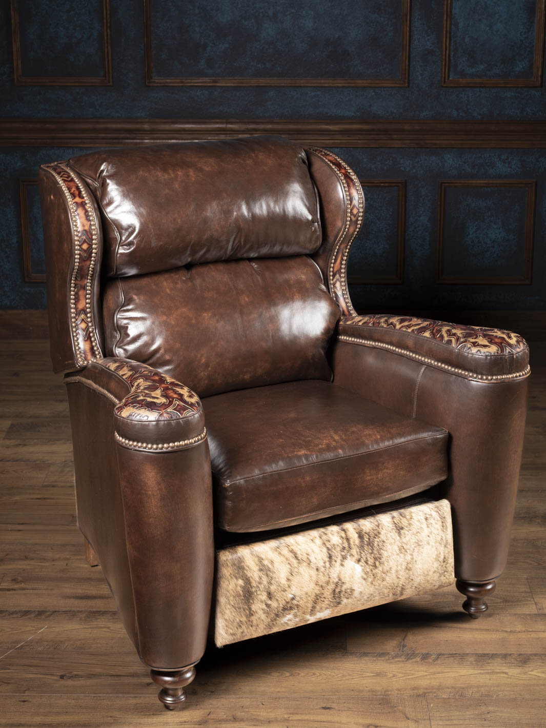 Side angle of the burnished brown leather recliner showing paneled arms and tall back