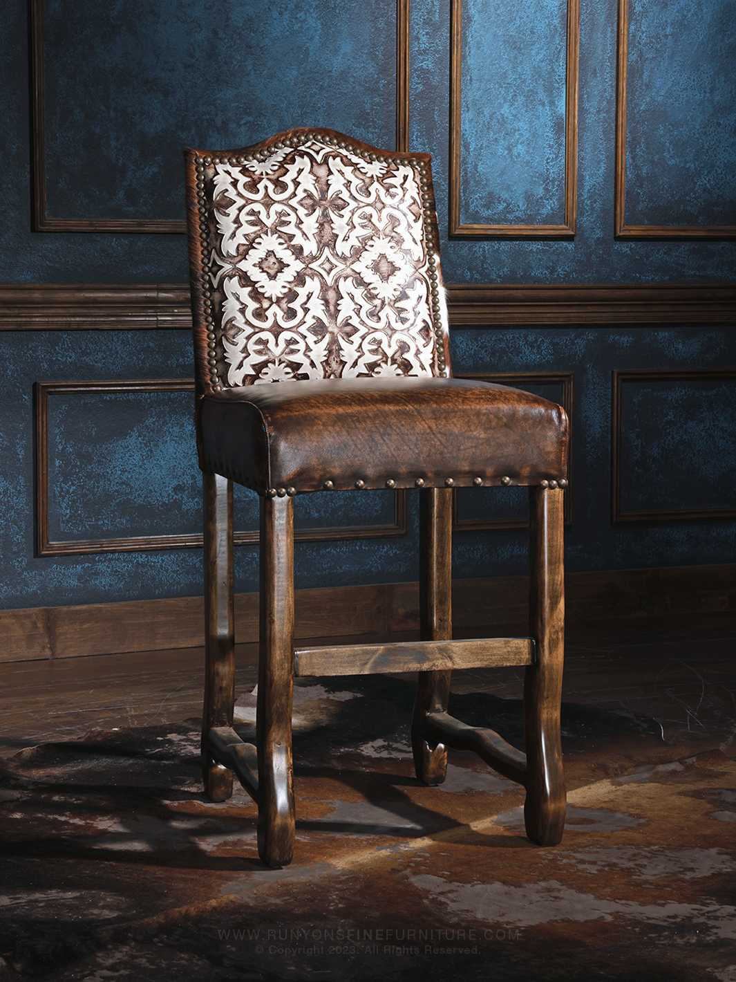 Cattleman’s Cowhide and Leather Bar Stool with burnished brown leather and embossed leather accents, in a studio setting.