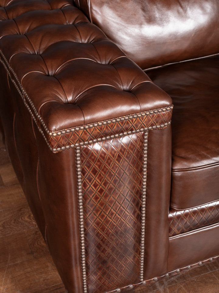 Tufted Cigar Lounge Leather Sofa with tufted button armrest and diamond stitch leather inlay in a close-up view.