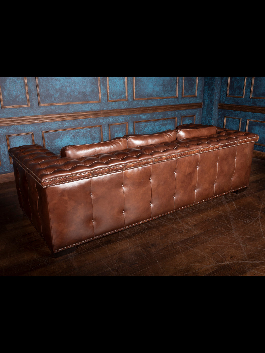 Tufted Cigar Lounge Leather Sofa in brown full-grain leather with tufted arm rest and outside back accents in a rustic room.