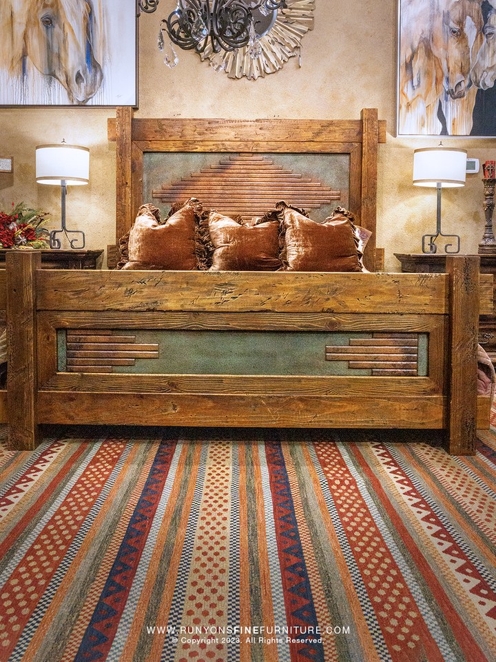 Wooden copper bed with decorative pillows in a bedroom setting, featuring a striped rug and wall art.