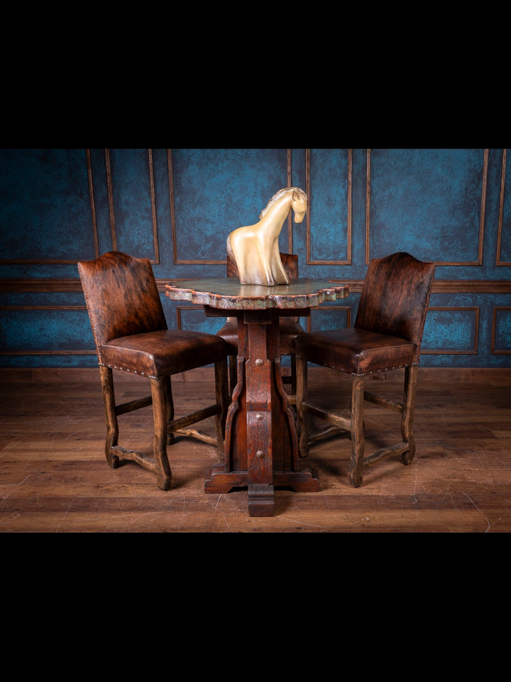 Wooden copper pub table with a horse sculpture and two brown leather chairs against a blue paneled wall.
