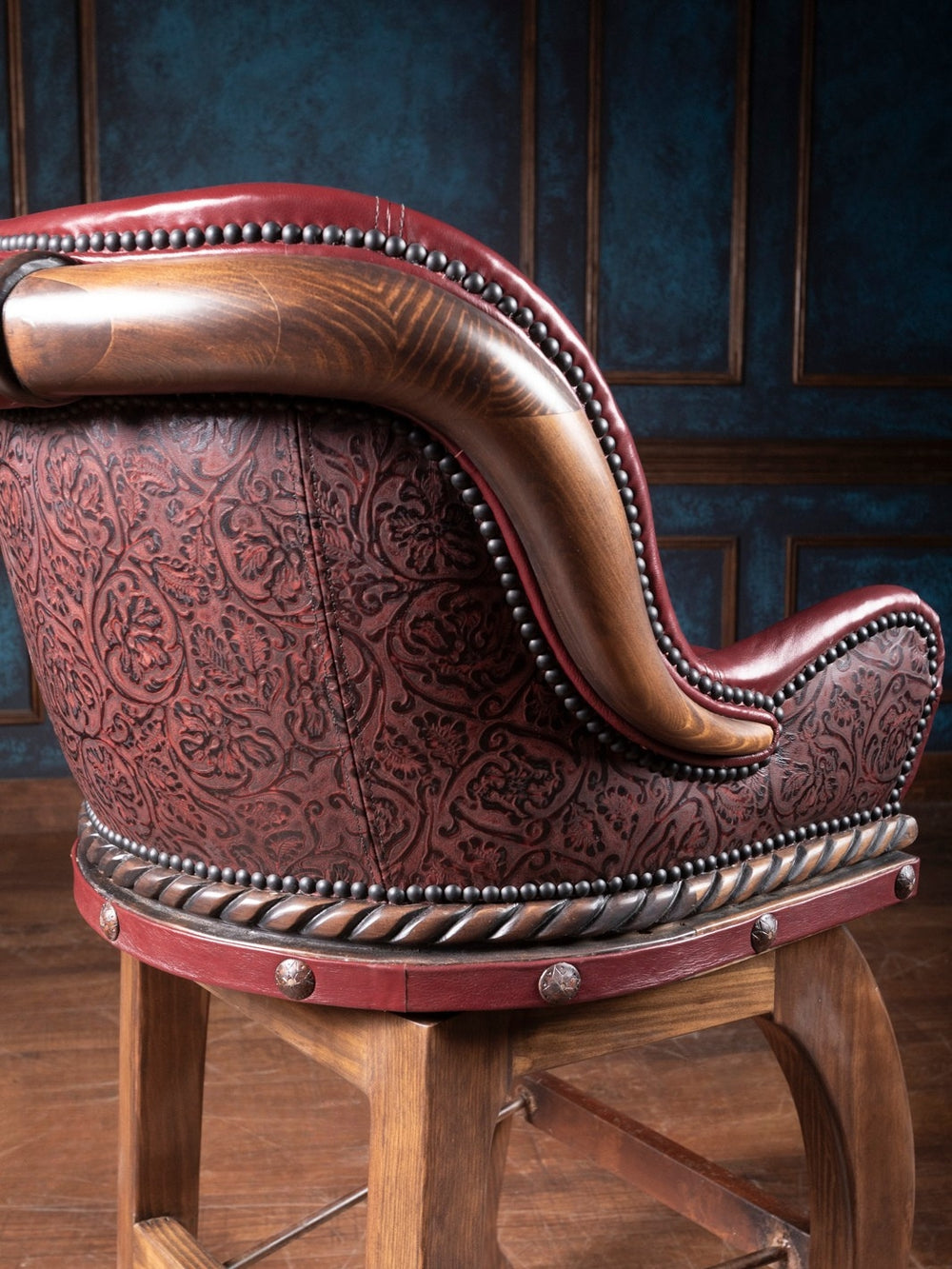 Cowboy Red Leather Bar Stool with embossed floral leather accented by brass nailhead trim, shown in a close-up view.