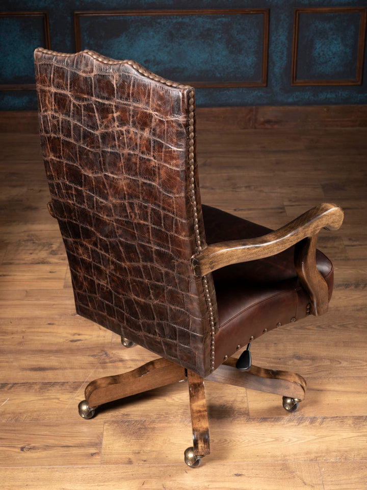 Three quarter rear view of the jumbo crocodile embossed leather high back and solid wood caster base on a Western executive desk chair.