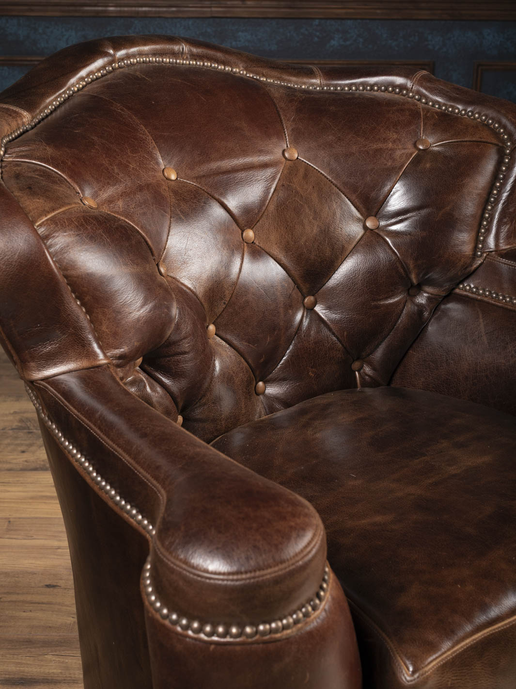 Close-up of diamond tufting and soft wax-finished Dark Rum buffalo leather on the swivel chair inback